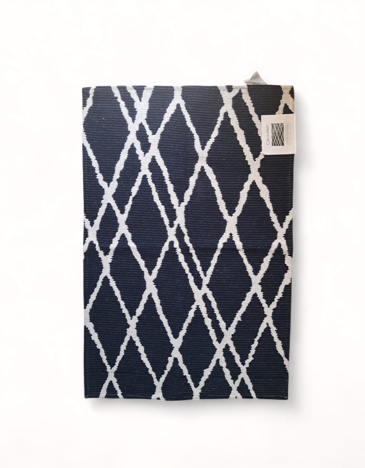 Tapete Calvin Klein accent rug 76x114 cm. Diseño geométrico diamantes en contraste. Estética minimalista moderna. Al pie de la cama o recibidor. Minicostos RM.